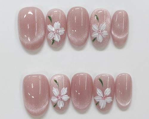 Pink nail art with white floral designs on a light gray background