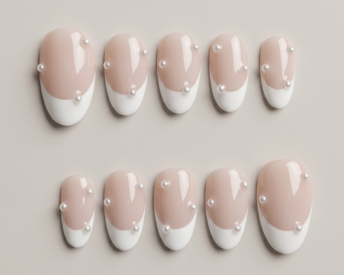 Set of nails with a gradient design featuring pink and white colors, decorated with small pearls on a neutral background.